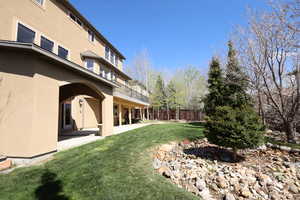 View of yard featuring fence, a patio, and a balcony