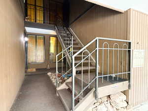 Staircase featuring wooden walls