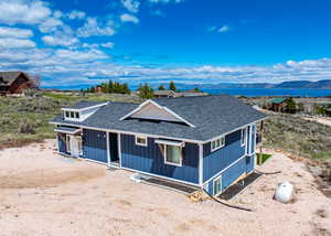 Country-style home featuring roof with shingles, a mountain view, and board and batten siding