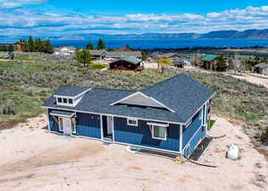 Birds eye view of property featuring a water and mountain view