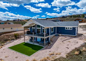 Rear view of property with roof with shingles, a patio, a lawn, and a residential view