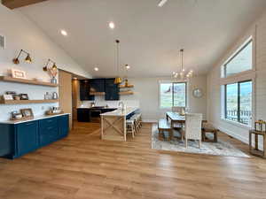 Dining room featuring high vaulted ceiling, a chandelier, and a wealth of natural light