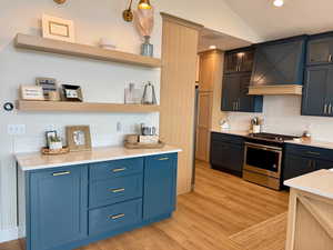 Interior space featuring stainless steel gas range, light wood finished floors, and tasteful backsplash