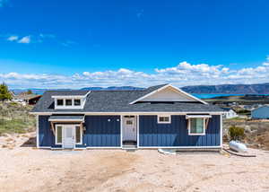 View of front of house with board and batten siding, a shingled roof, and a mountain view