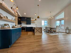 Kitchen featuring open shelves, stainless steel range, light countertops, high vaulted ceiling, and blue cabinets