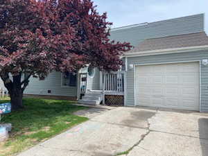 View of front facade with driveway, an attached garage, and a front lawn