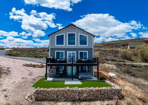 house with a hot tub, a wooden deck, board and batten siding, a patio area, and french doors