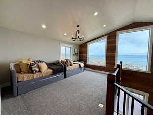 Loft area featuring wooden walls, an inviting chandelier, carpet floors, recessed lighting, and vaulted ceiling