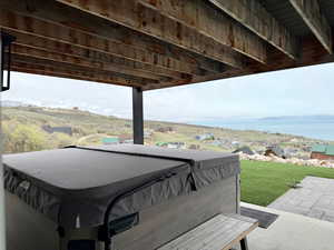 Exterior space with a water view and a hot tub