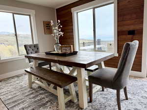 Dining area with wooden walls, baseboards, and light wood finished floors
