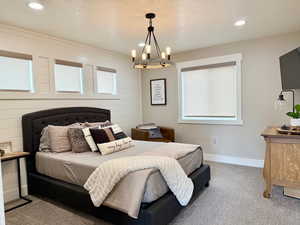 Bedroom with an inviting chandelier, recessed lighting, baseboards, and carpet floors