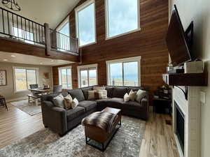 Living area with light wood-style floors, plenty of natural light, and a towering ceiling