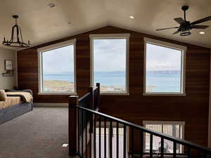 Loft featuring vaulted ceiling, wood walls, and carpet flooring