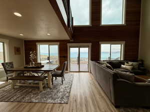 Dining room featuring recessed lighting, wood walls, light wood finished floors, and a healthy amount of sunlight