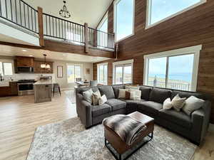 Living area with a high ceiling, a notable chandelier, and a healthy amount of sunlight