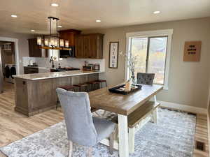Dining space with recessed lighting, an inviting chandelier, and light wood-type flooring