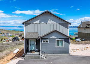 View of front facade featuring board and batten siding and a water view