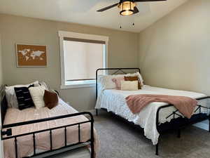 Carpeted bedroom featuring baseboards and a ceiling fan