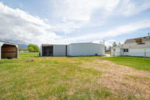 View of yard with fence and an outbuilding