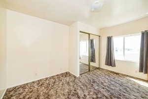 Unfurnished bedroom featuring baseboards, carpet, and a closet
