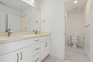 Full bath with double vanity, visible vents, a stall shower, a sink, and toilet