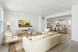 Living area with recessed lighting, visible vents, and light wood-style flooring