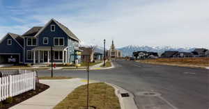 View of road featuring street lighting, curbs, a mountain view, and sidewalks