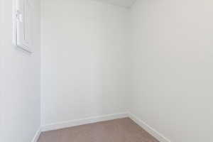 Interior space with baseboards and light colored carpet