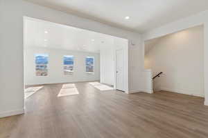 Unfurnished room with light wood-type flooring, recessed lighting, and baseboards