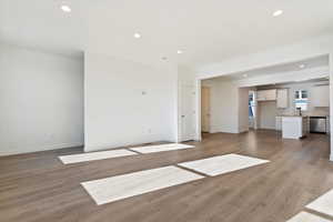 Unfurnished living room with baseboards, light wood finished floors, and recessed lighting