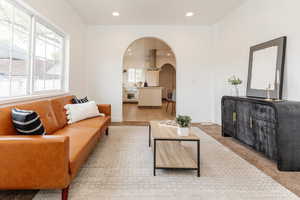 Living room with recessed lighting, baseboards, and arched walkways