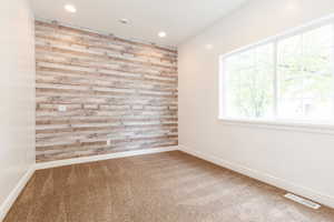 Spare room featuring visible vents, carpet, and baseboards
