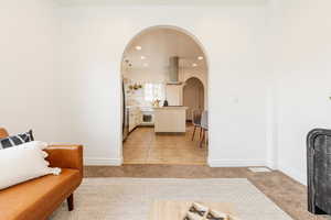 Living room featuring visible vents, recessed lighting, arched walkways, and light colored carpet