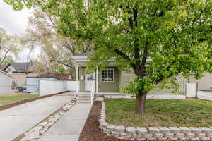 View of front of home with concrete driveway, a front yard, and fence