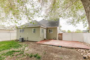 Rear view of house with a shingled roof, a fenced backyard, a wooden deck, and central air condition unit
