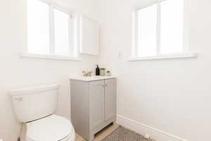 Bathroom with baseboards, toilet, and vanity