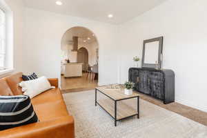 Living area featuring recessed lighting, arched walkways, and a healthy amount of sunlight