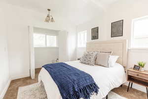 Carpeted bedroom with baseboards and multiple windows