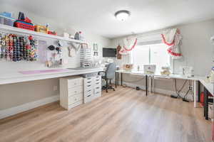 Office with light wood-type flooring and baseboards