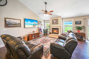 Living room featuring plenty of natural light, baseboards, ceiling fan, and wood finished floors