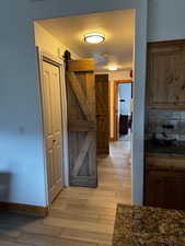 Hall with light wood finished floors and baseboards