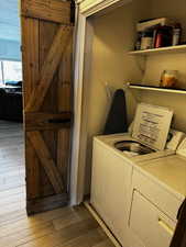 Laundry room with separate washer and dryer, laundry area, and light wood-style flooring