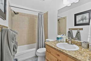 Full bathroom featuring vanity, toilet, and shower / tub combo with curtain