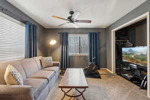 Carpeted living area featuring baseboards and a ceiling fan