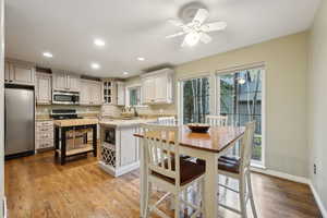 Kitchen with light stone countertops, appliances with stainless steel finishes, a sink, a ceiling fan, and recessed lighting