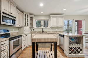 Kitchen with a sink, stainless steel appliances, a peninsula, and a wealth of natural light