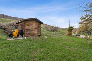 View of yard featuring a storage unit and an outbuilding