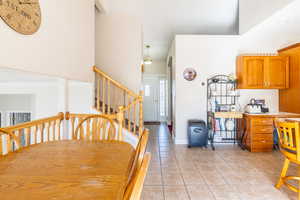 Dining area featuring stairs, crown molding, baseboards, and light tile patterned floors