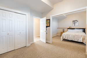 Carpeted bedroom featuring baseboards and a closet