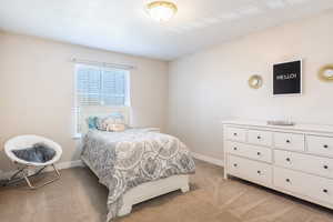 Bedroom featuring light colored carpet and baseboards